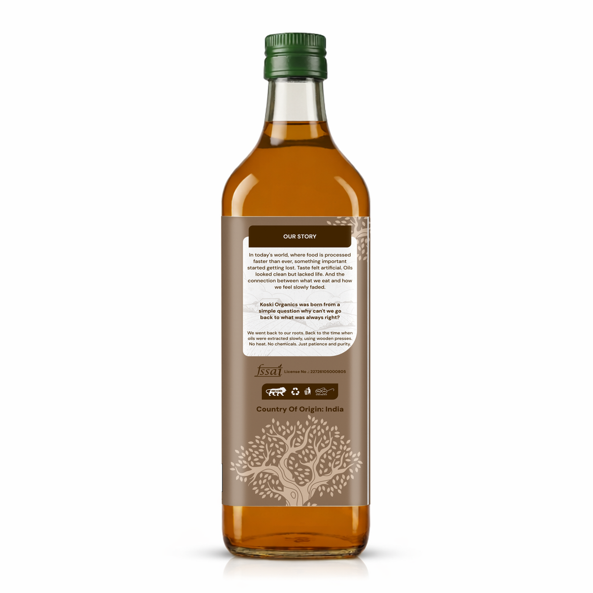 A bottle of coconut oil shown from the back, featuring a dark brown label with white text and illustrations, a green cap, and amber-colored liquid inside a clear glass bottle on a white background.